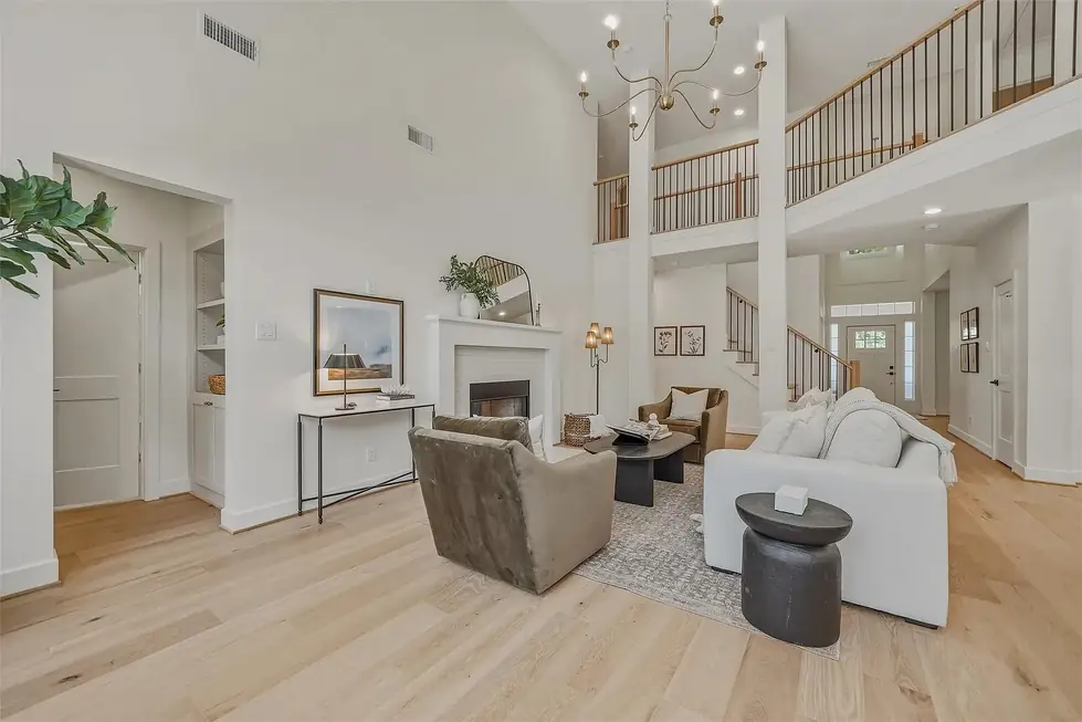A two-storey living room with a new oak floor, a sofa, armchairs and a fireplace